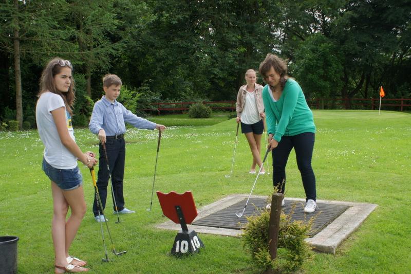 Al soggiorno studio inglese quattro ragazzi sono sul prato a giocare a golf