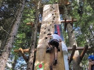 Al campo estivo all'estero un ragazzo si sta arrampicando su un muro da arrampicata