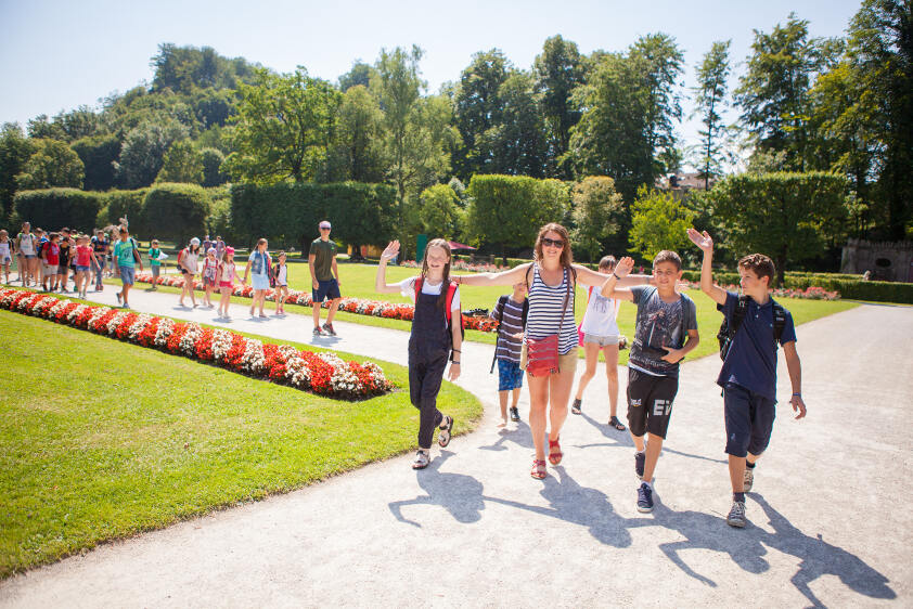 Durante il viaggio per ragazzi all'estero, i ragazzi vistano un parco accompagnati da una guida e salutano il fotografo
