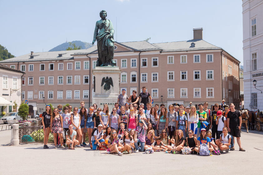 Il grande gruppo di partecipanti dei soggiorni linguistici Spagna posa per la foto di gruppo davanti ad una statua