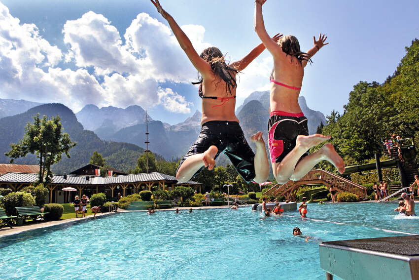 Due ragazze in costume del campo estivo in inglese si stanno tuffando in piscina