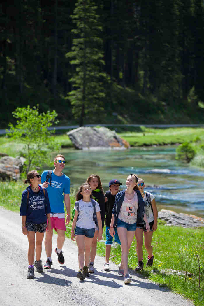 Un gruppo di ragazzi passeggia vicino a un fiume al campo estivo in inglese
