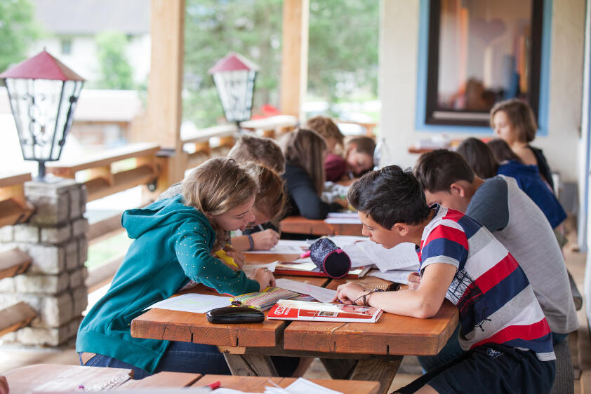 Durante i campi estivi Inghilterra, i ragazzi studiano la lingua sui libri seduti su tavoli all'aperto