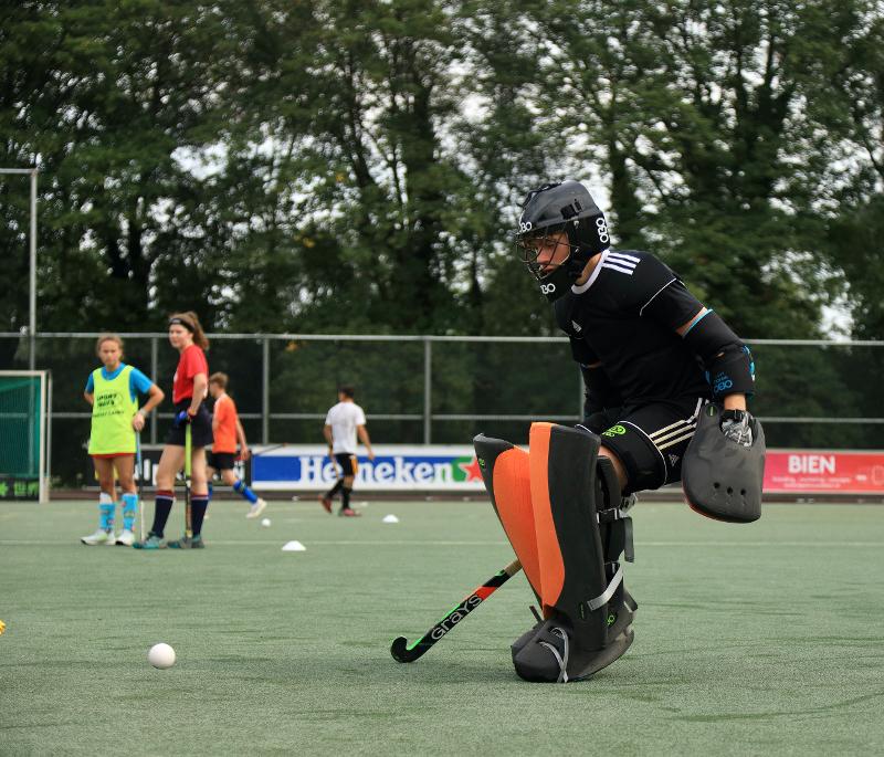 Al campo estivo hockey  ci sono ragazzi in campo in azione che stanno facendo allenamento di hockey 