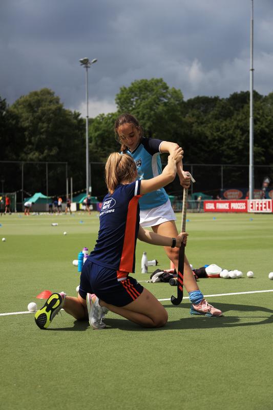 Al campo estivo hockey ad Amsterdam l'insegnante insegna all'allieva come impugnare la mazza
