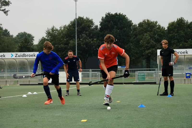  Al campo estivo hockey ad Amsterdam due ragazzi stanno facendo un esercizio di coppia per la loro tecnica 