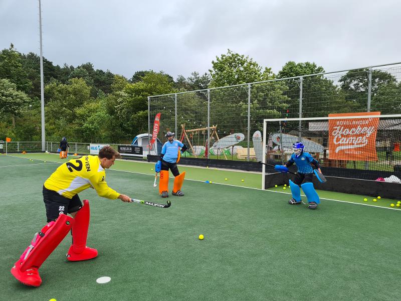 L'allenatore dei portieri fa esercitare i partecipanti del campo estivo hockey