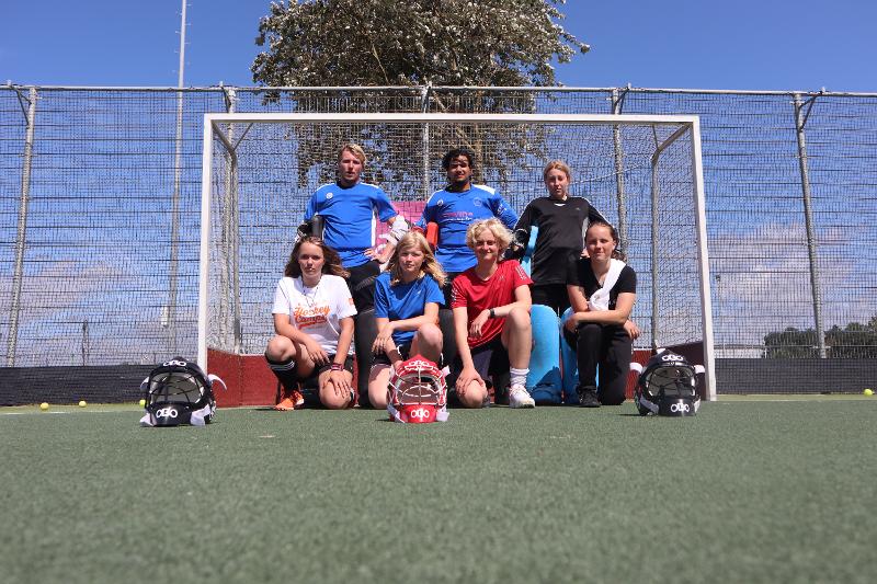 Le ragazze del campo estivo hockey sono davanti alla porta per una foto di gruppo