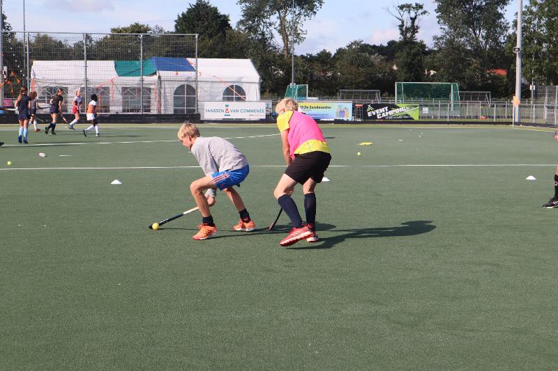 Due partecipanti del campo estivo hockey si scontrano uno contro uno 