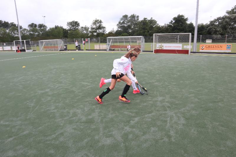 Due ragazze del campo estivo hockey si sfidano con dribbling e contrasti
