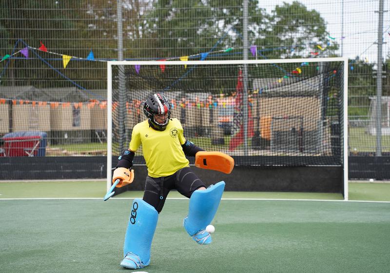 Uno dei portieri del campo estivo hockey para una palla bassa