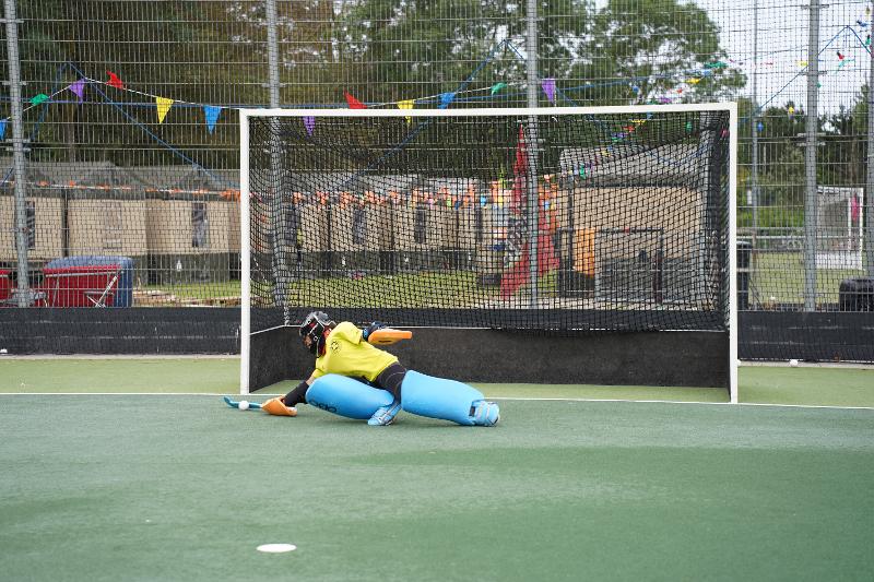 Il portiere del campo estivo hockey si tuffa per parare un tiro insidioso