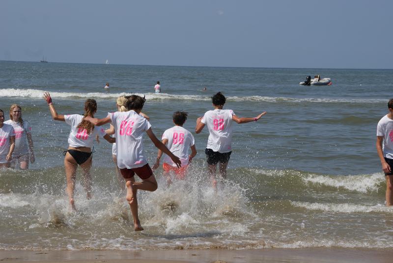 Un gruppo di ragazzi del campo estivo sport acquatici corre per tuffarsi in mare