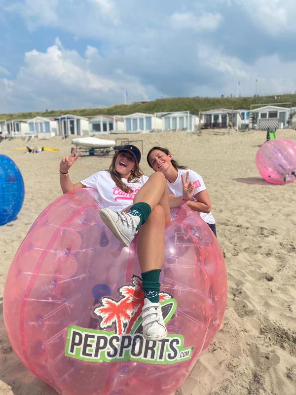 Due partecipanti sono sedute su gonfiabili rosa al campo estivo sport acquatici