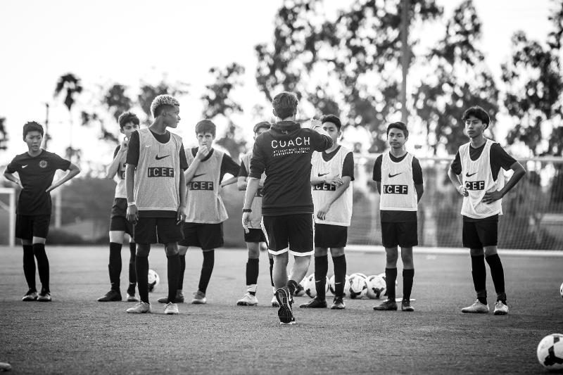coach segue l'allenamento in campo sei ragazzi