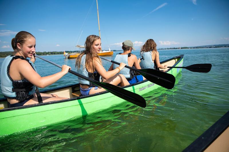 Al campo internazionale sul Lago Costanza ci sono dei ragazzi che stanno facendo canoa al lago