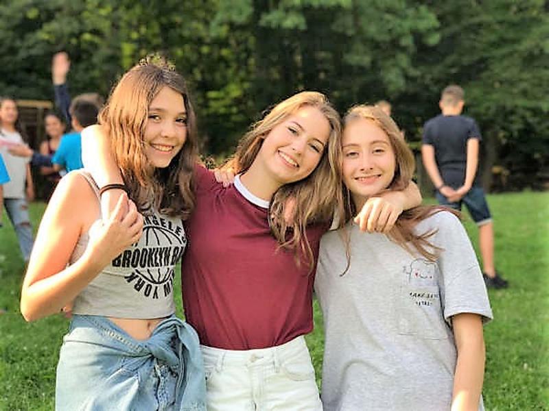 Al campo internazionale sul Lago Costanza ci sono tre ragazze che si abbracciano e sorrdono
