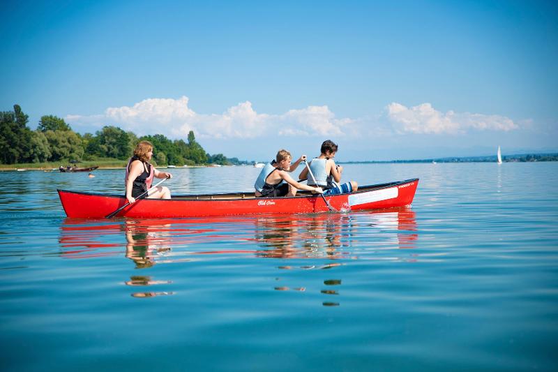 Al campo internazionale sul Lago Costanza ci sono tre ragazzi in canoa che si dirigono nel lago