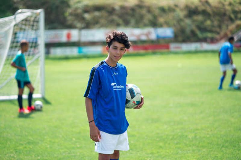 Al campo internazionale sul Lago Costanza c'è un ragazzo che sta tenendo un pallone da calcio in campo 