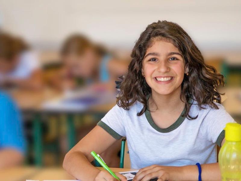 Al  campo internazionale sul Lago Costanza una ragazza sta sorridendo mentre fa i compiti 