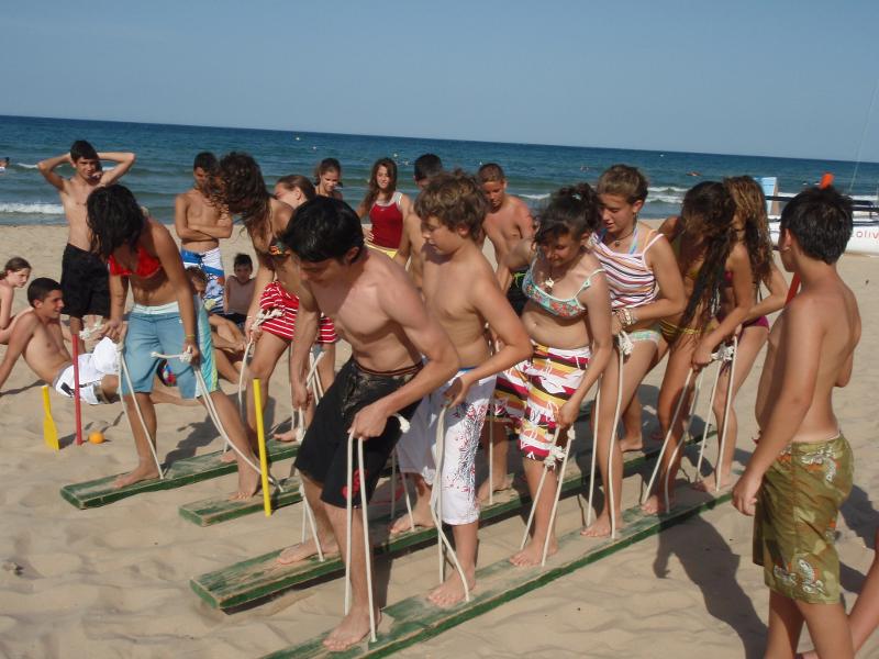 Al campo estivo surf, alcuni ragazzi praticano attività e giochi di gruppo in riva al mare