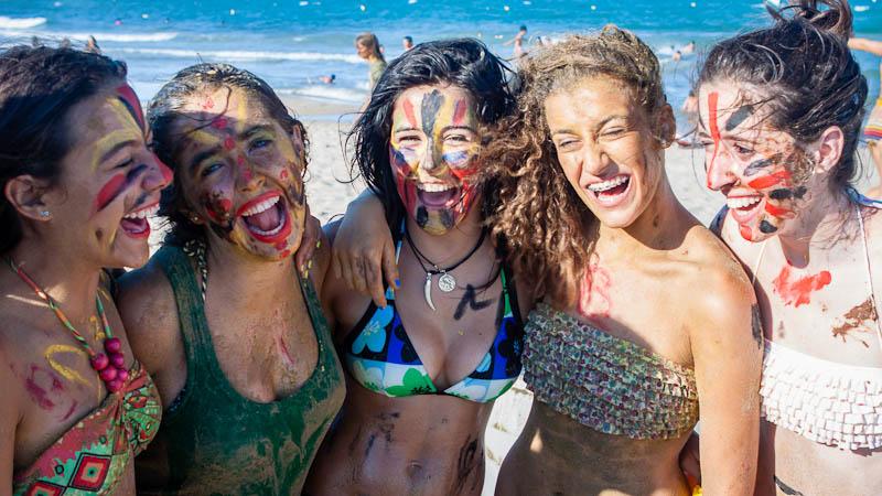 Al campo estivo surf le ragazze si divertono in spiaggia pitturando le loro facce