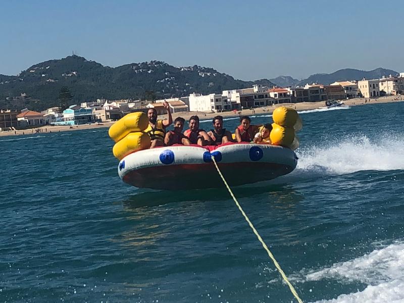 Alcuni ragazzi con il giubbotto di salvataggio stanno provando un gonfiabile in movimento tra le onde nelle vacanze per ragazzi 16 anni