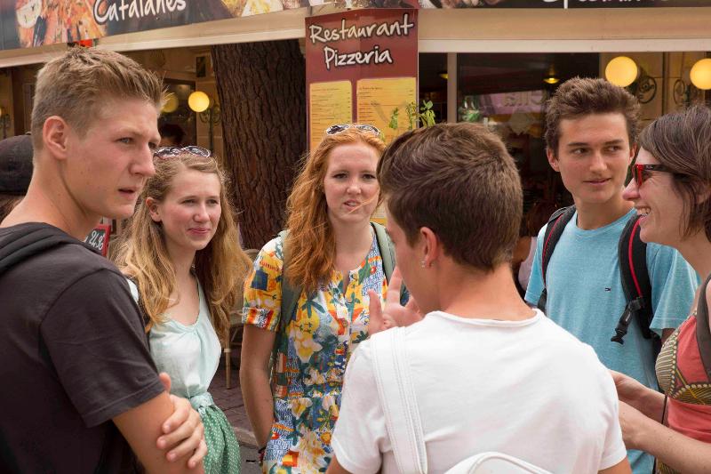 Un gruppo di ragazzi al soggiorno linguistico francese sono in piedi in cerchio a parlare