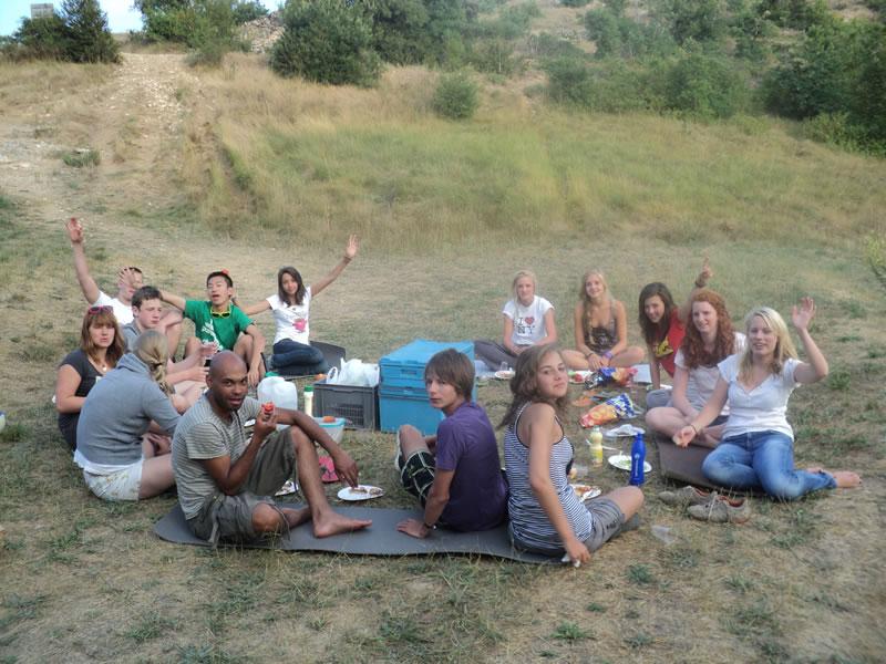 Durante il soggiorno linguistico in francese, i ragazzi sono seduti sul prato e stanno facendo un picnic tutti insieme