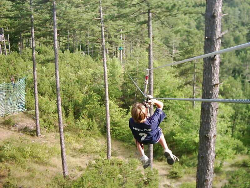 Un partecipante del soggiorno linguistico francese scende lungo una zip line