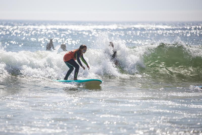 Una ragazza cavalca le onde ai viaggi surf organizzati