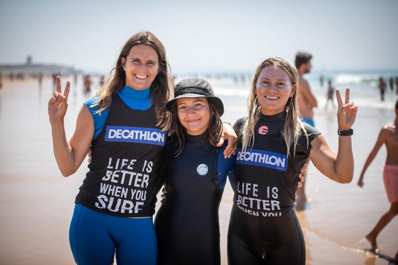 Ai viaggi surf organizzati tre ragazze sorridono e si abbracciano facendo il simbolo della pace