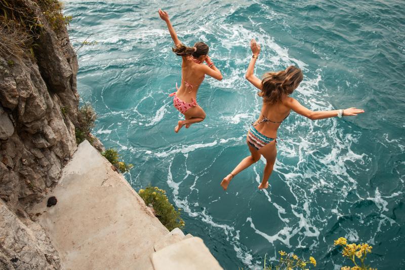 Un ragazzo si tuffa nel bellissimo mare blu dei viaggi organizzati Sicilia
