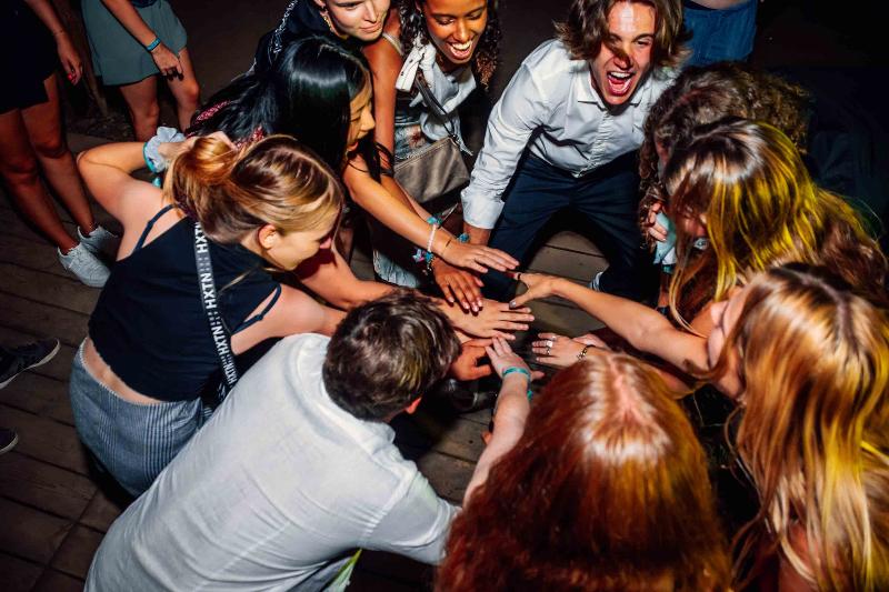 Ai viaggi per giovani Trento un gruppo di ragazzi sta ballando in cerchio in discoteca