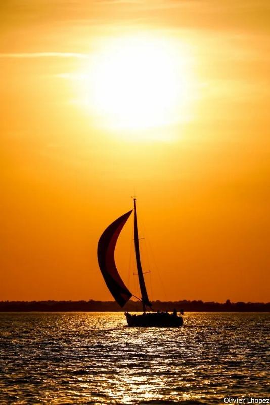Al soggiorno linguistico c'è una braca a vela che sta navigando in mare al tramonto 
