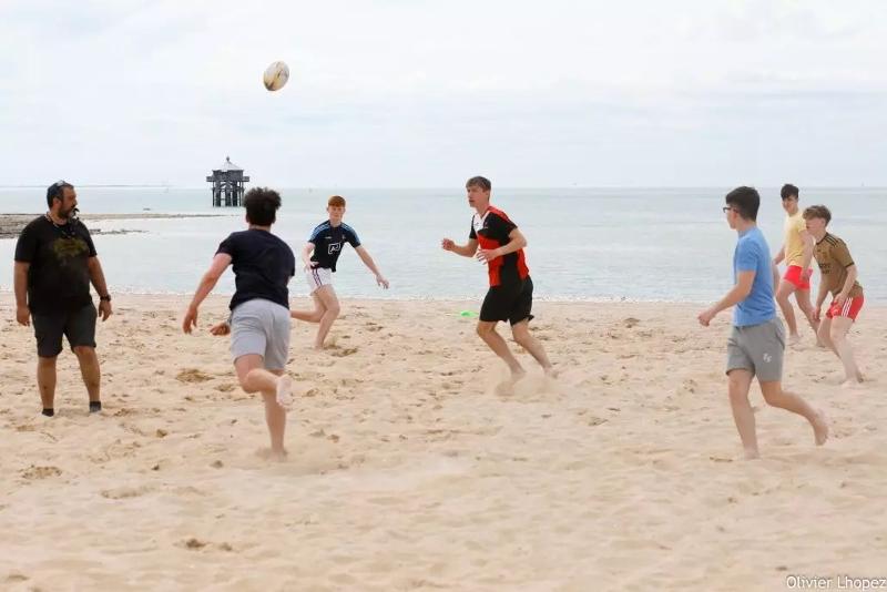 Al soggiorno linguistico i ragazzi stanno giocando in spiaggia con una palla