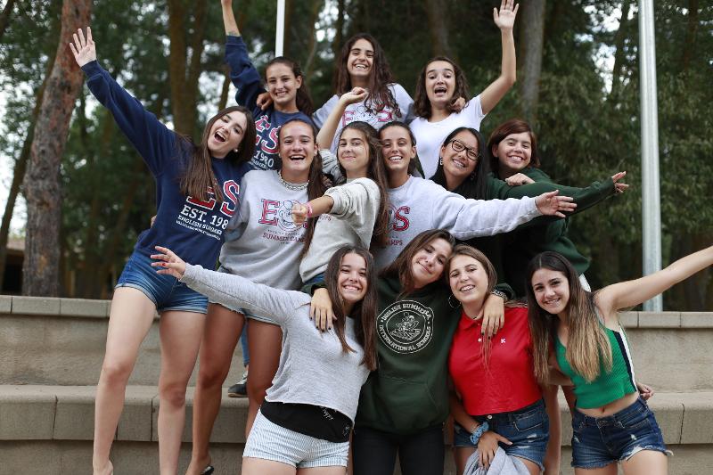 Al campo estivo internazionale tante ragazze si abbracciano e sorridono insieme