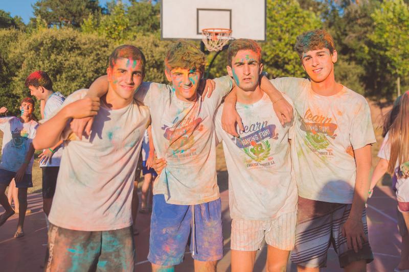 Al campo estivo in Spagna, quattro ragazzi scattano una foto e sono tutti pieni di colori addosso