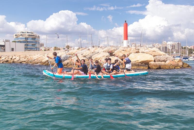 Alcuni ragazzi del campo estivo Malta fanno stand up paddling insieme in mare