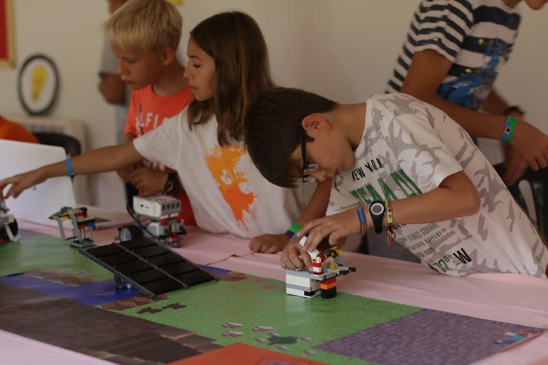 Al campo estivo robotica un ragazzo sta costruendo un piccolo robot