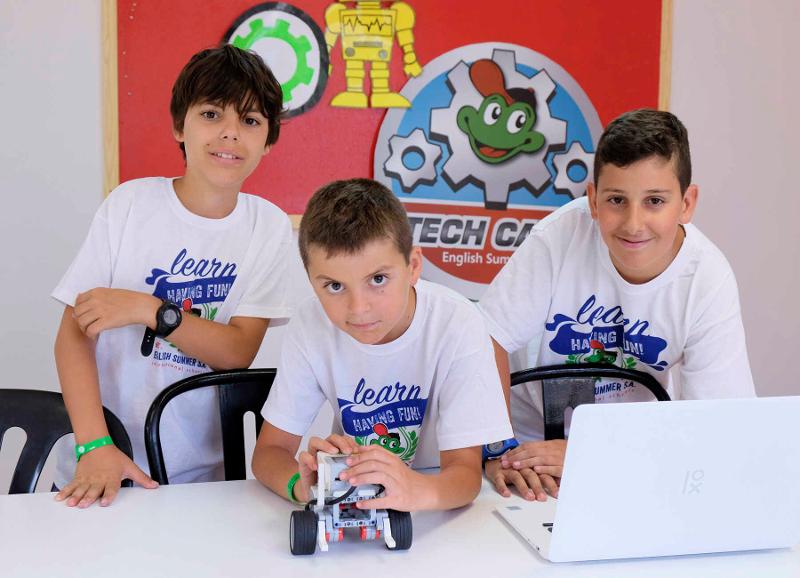 Al campo estivo robotica tre ragazzi sorridono