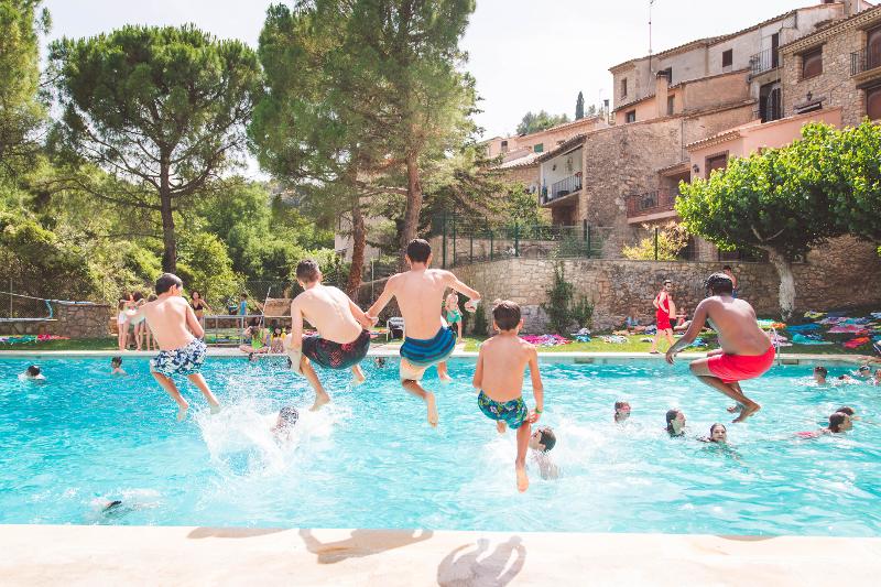 Al campo estivo Malta alcuni ragazzi si stanno tuffando in piscina in costume
