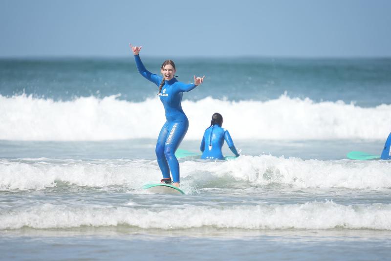 Una ragazza cavalca un'onda al campo estivo surf