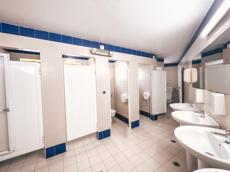 Bagni comuni spaziosi e puliti al campo estivo surf
