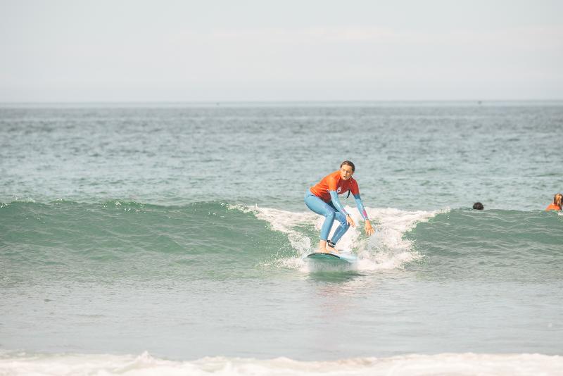 Una ragazza cavalca un'onda al campo estivo surf