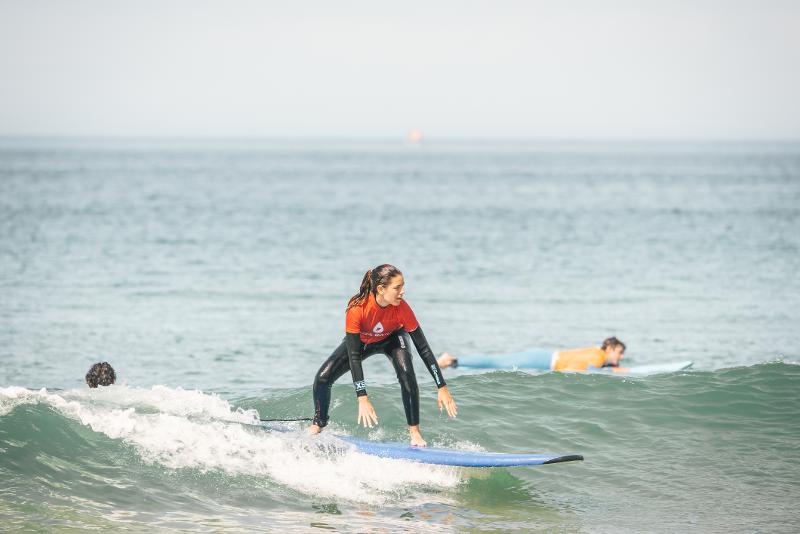 Una ragazza del campo estivo surf cavalca un'onda senza paura