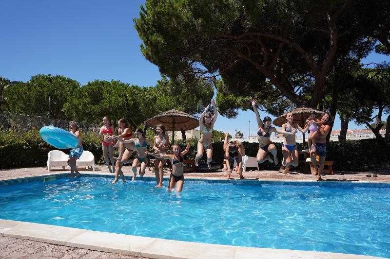 I ragazzi si tuffano in piscina al campo estivo surf