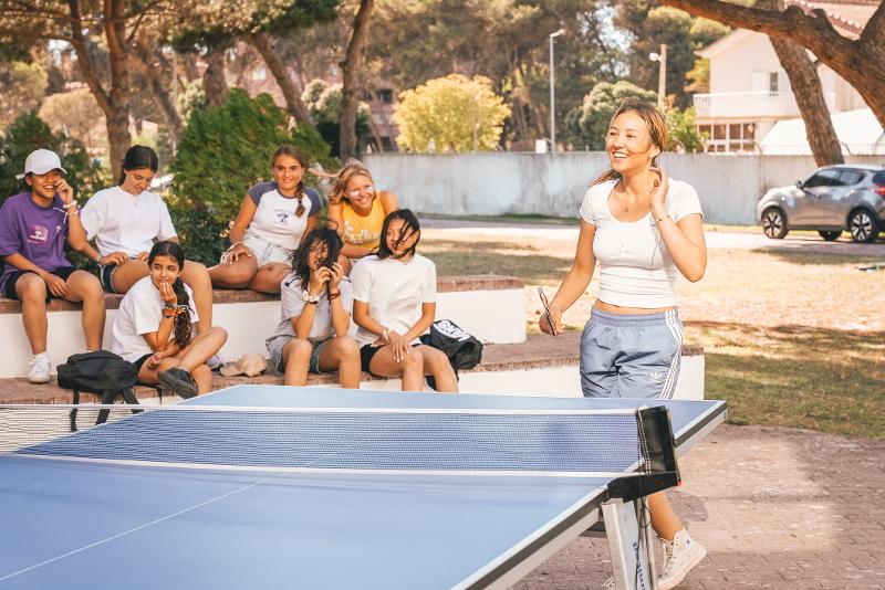 Una ragazza gioca a ping-pong al campo estivo surf