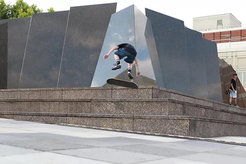 un ragazzo fa un trick lo skateboard davanti ad un monumento di Berlino