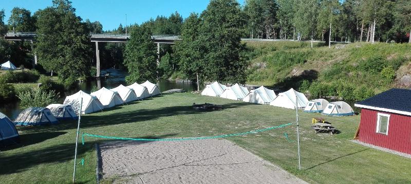 Al campo avventura in Svezia si vede un campo da beach volley con attorno delle tende sul prato